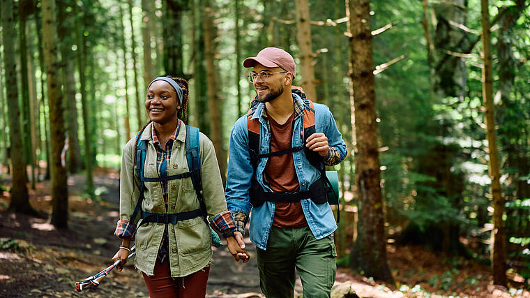 Pärchen wandert in durch einen Bergwald